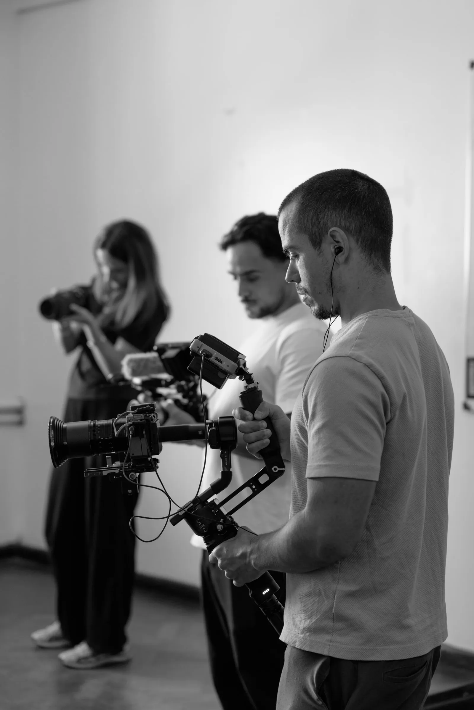 Three crew members framing a shot on a camera stabilizer.